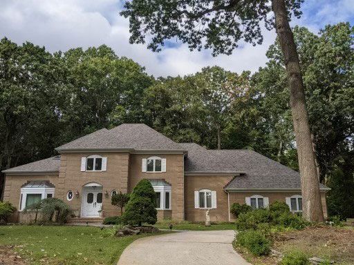 A large brick house with a tree in front of it
