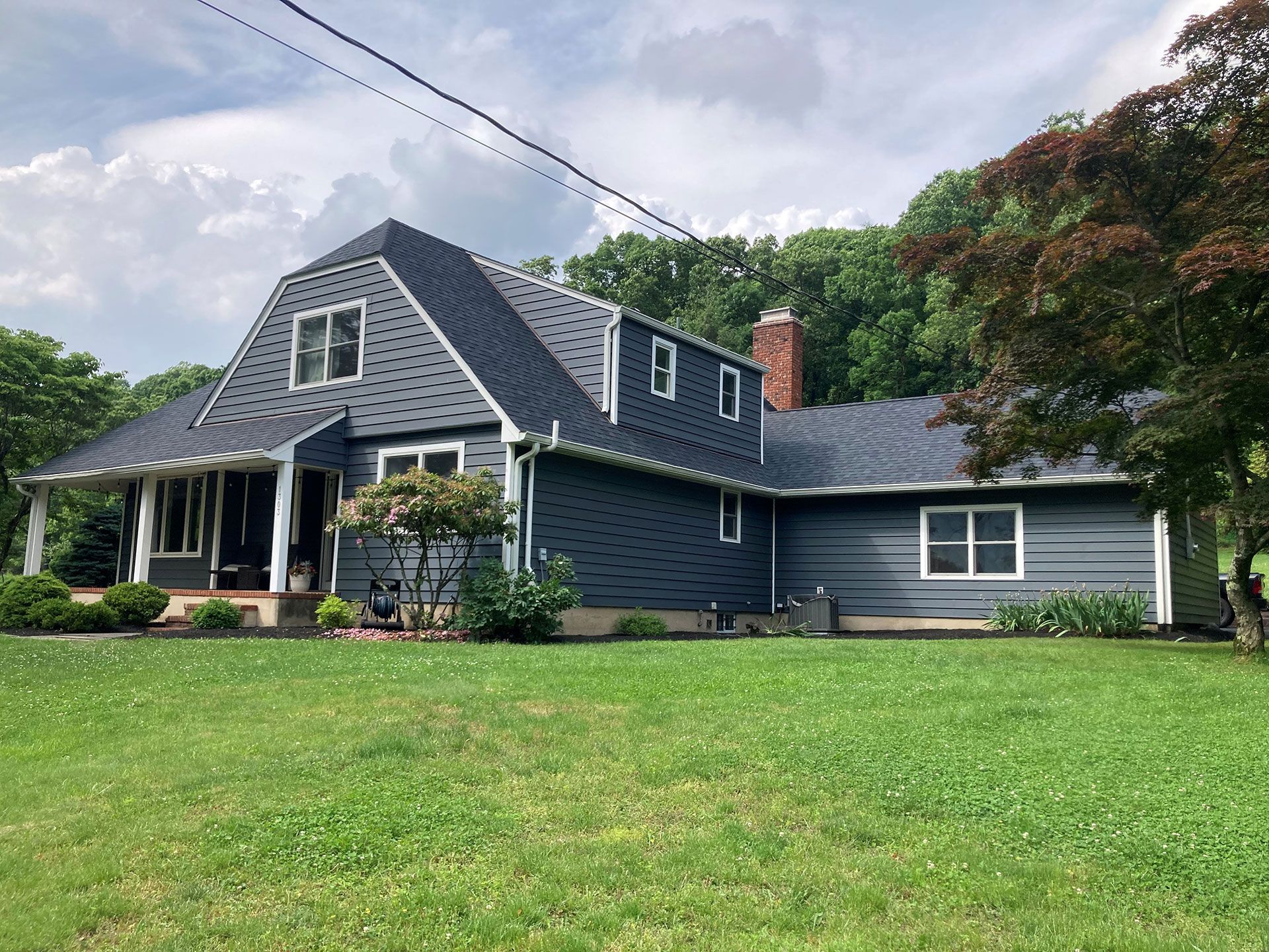 A large house is sitting on top of a lush green field