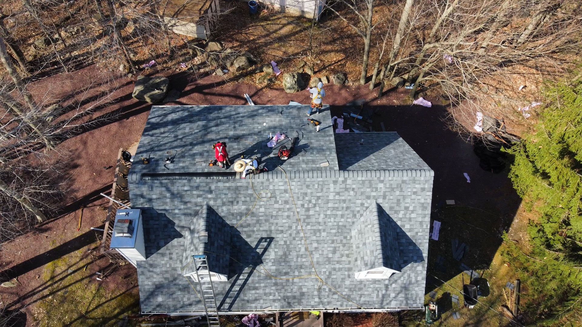 An aerial view of a house with a roof being repaired