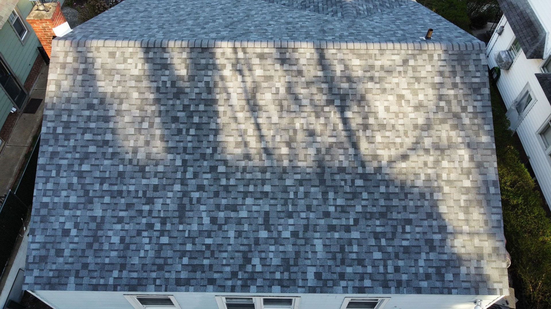 An aerial view of a house with a gray roof