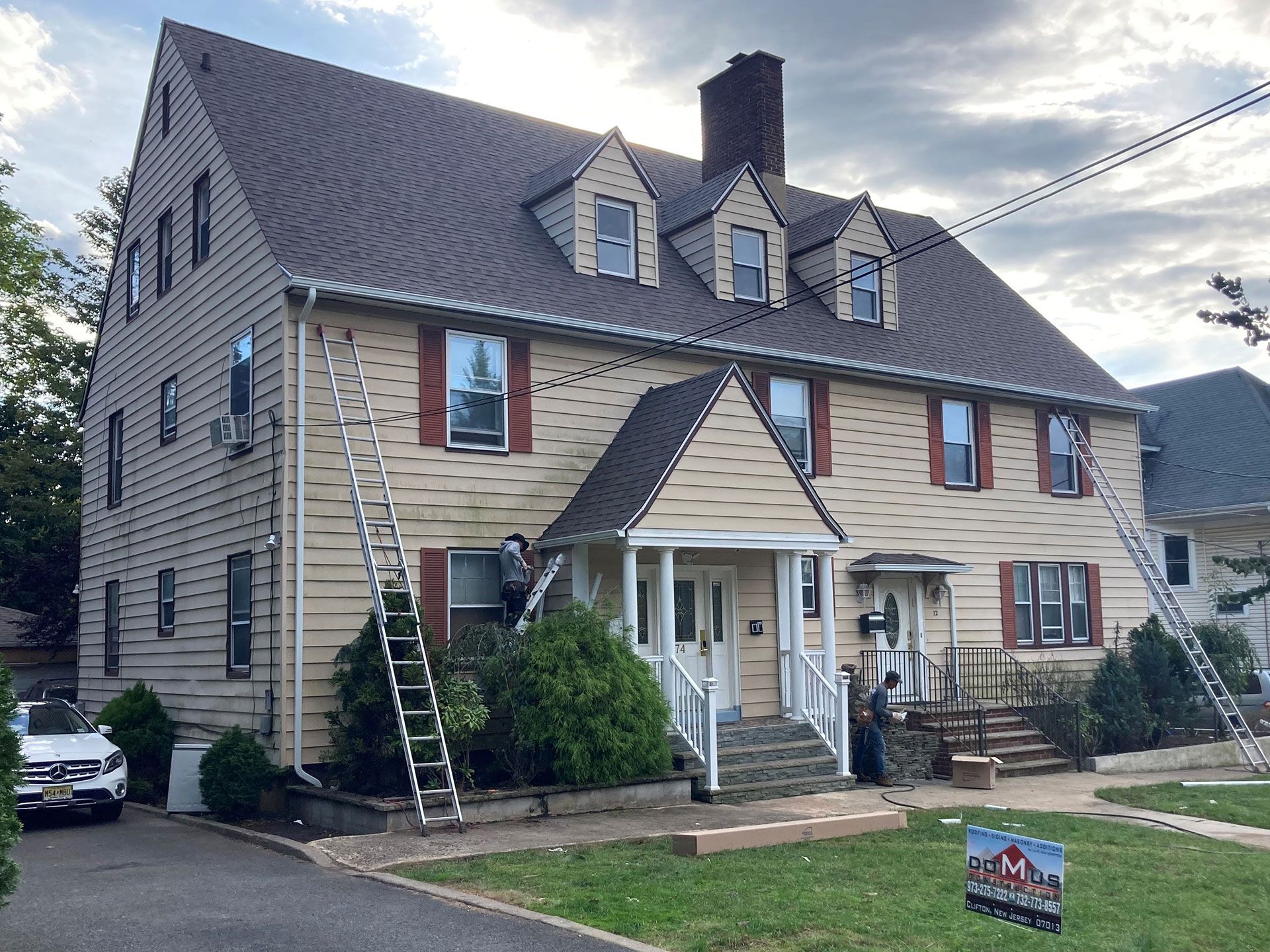 A large house with a metal roof is being painted