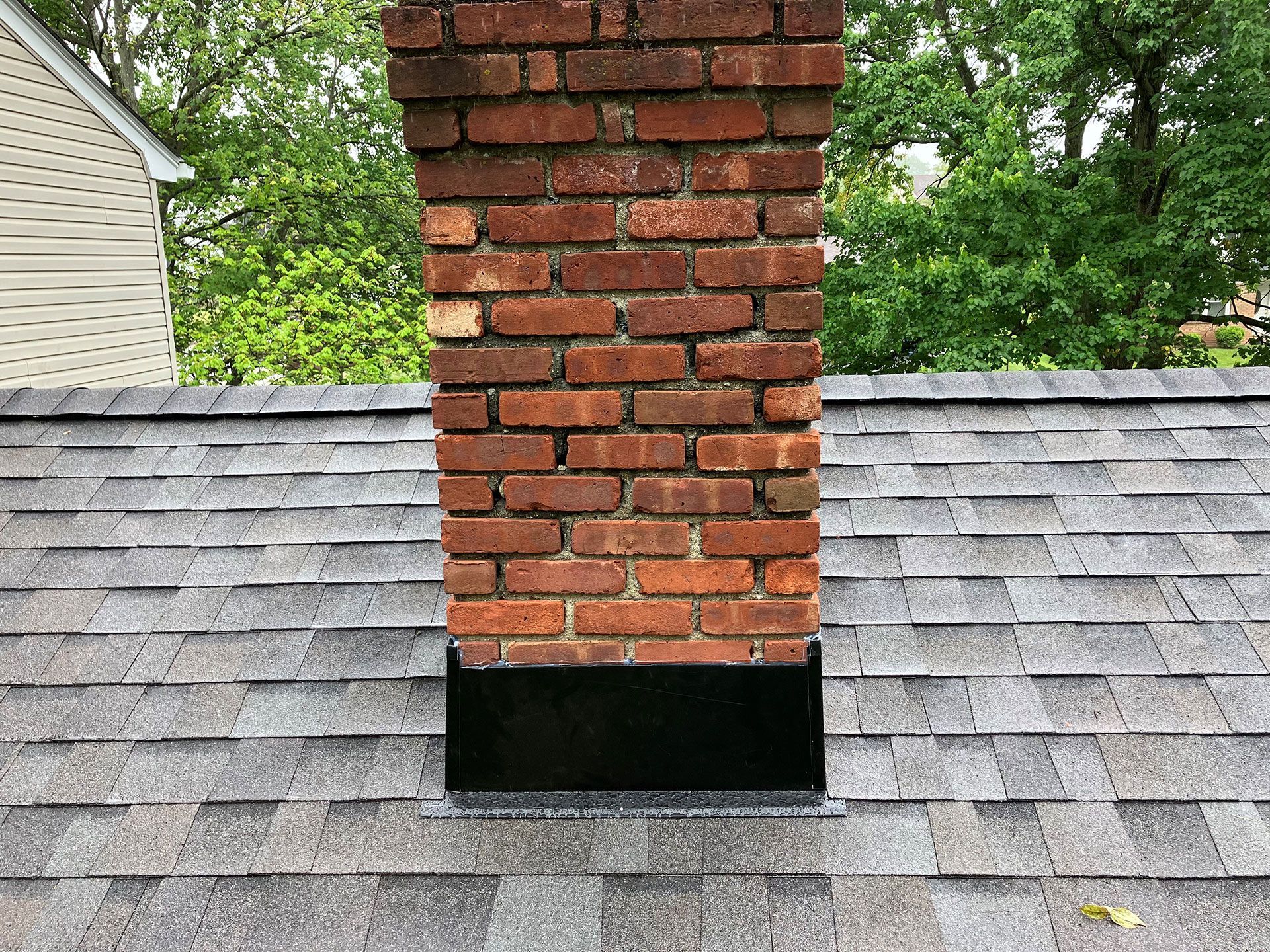 An aerial view of a brick chimney that is sitting on top of a roof