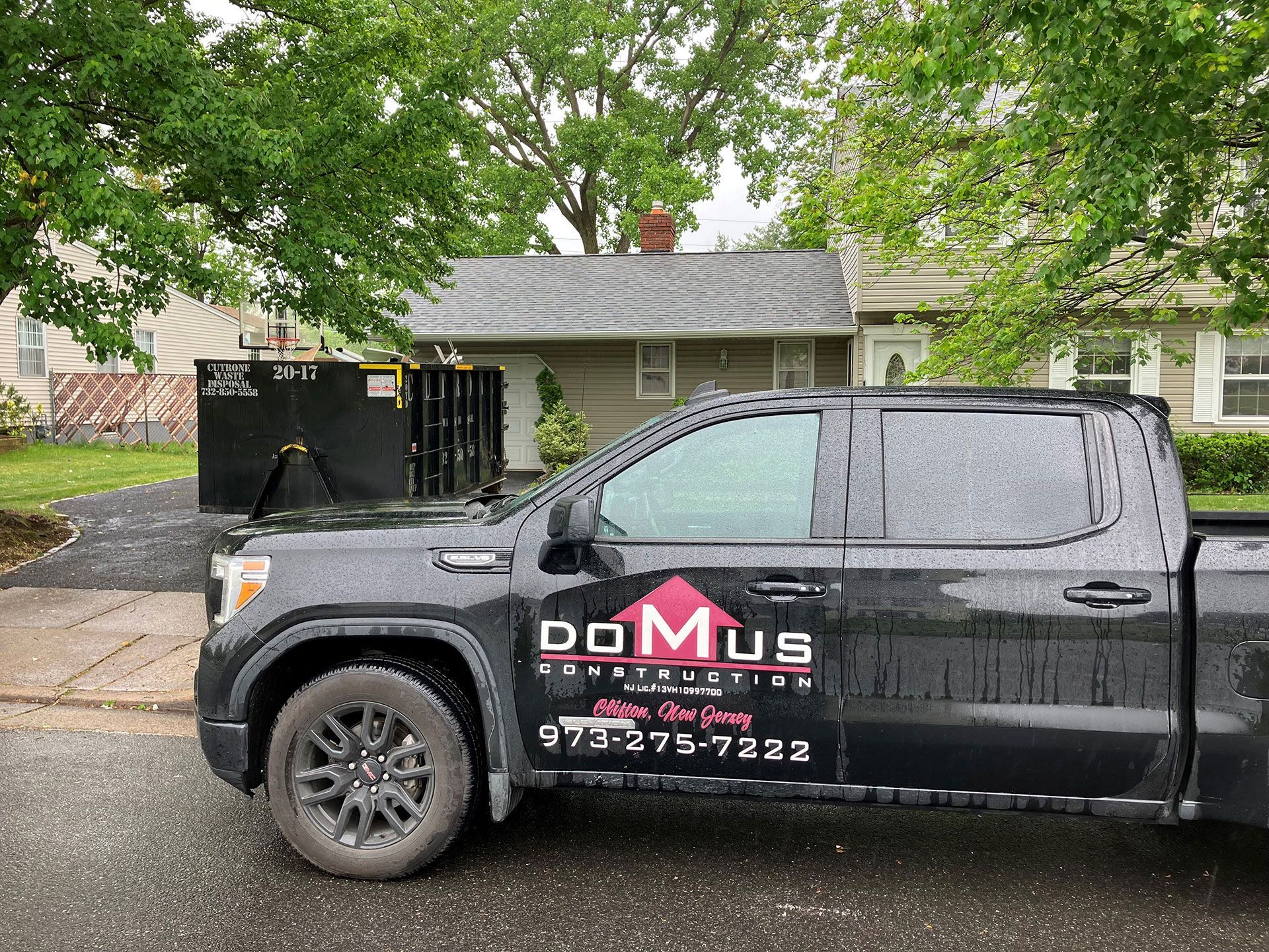 A black truck is parked in front of a house