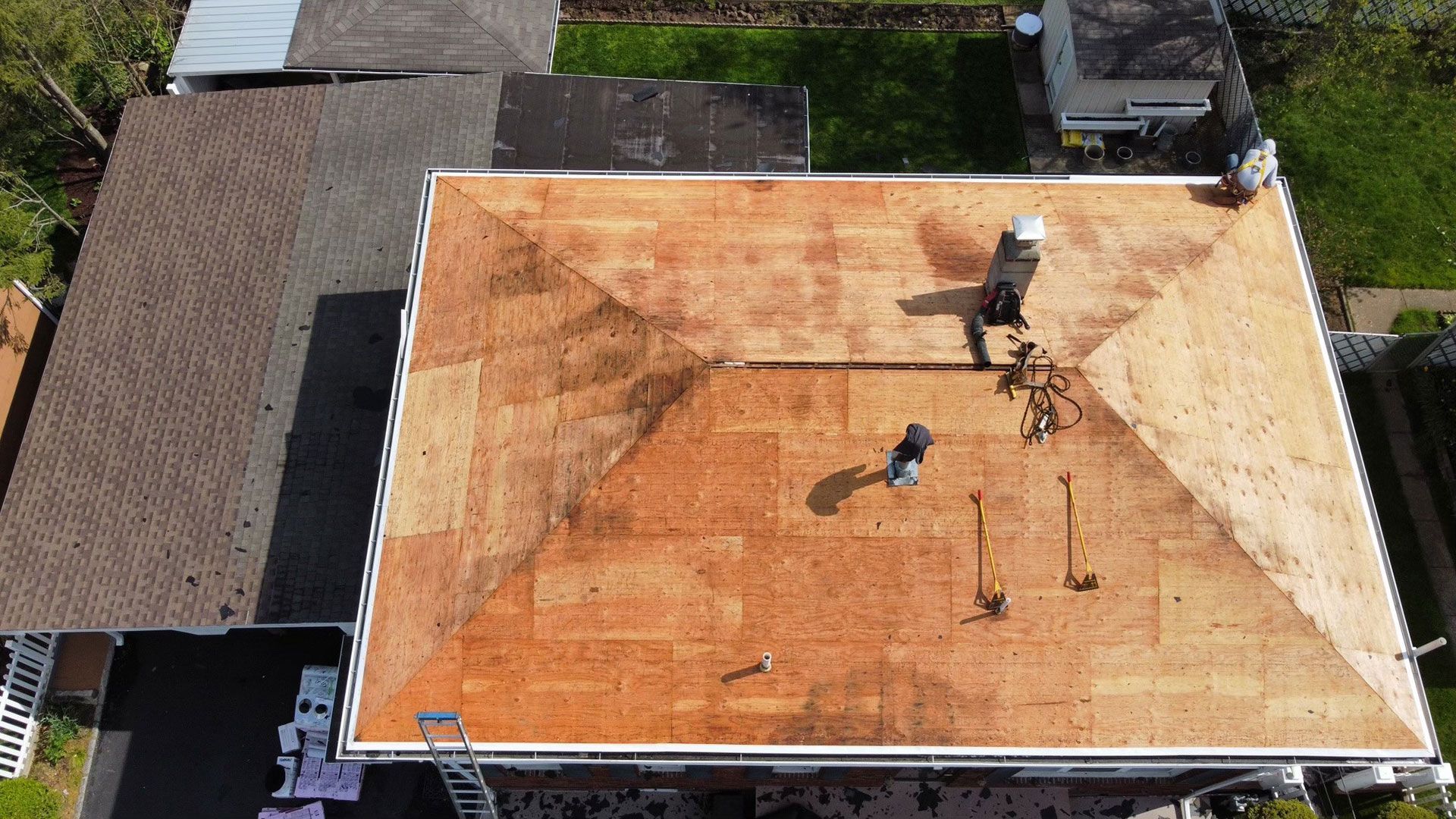 An aerial view of a roof being installed on a house