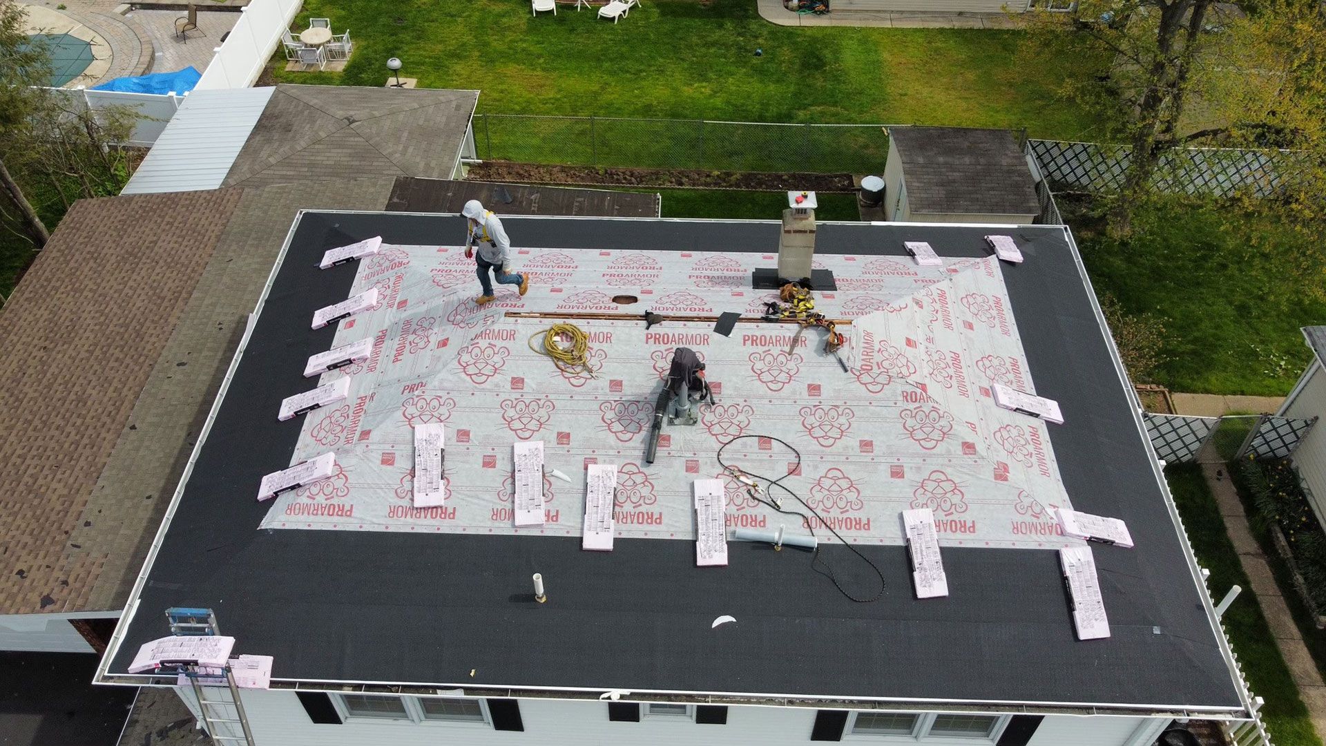 A group of people are working on the roof of a house