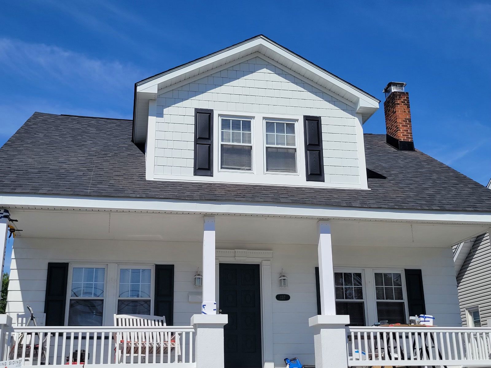 A white house with a black roof and black shutters