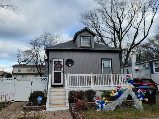 A house with a white fence and a Christmas decoration in front of it
