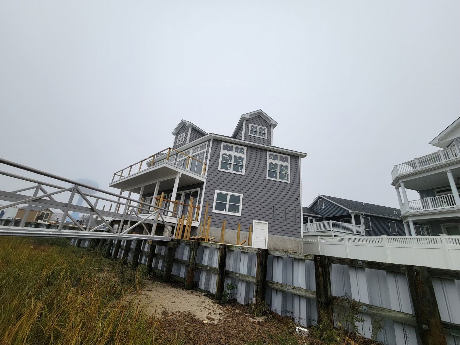 A large house is sitting on top of a hill next to a dock