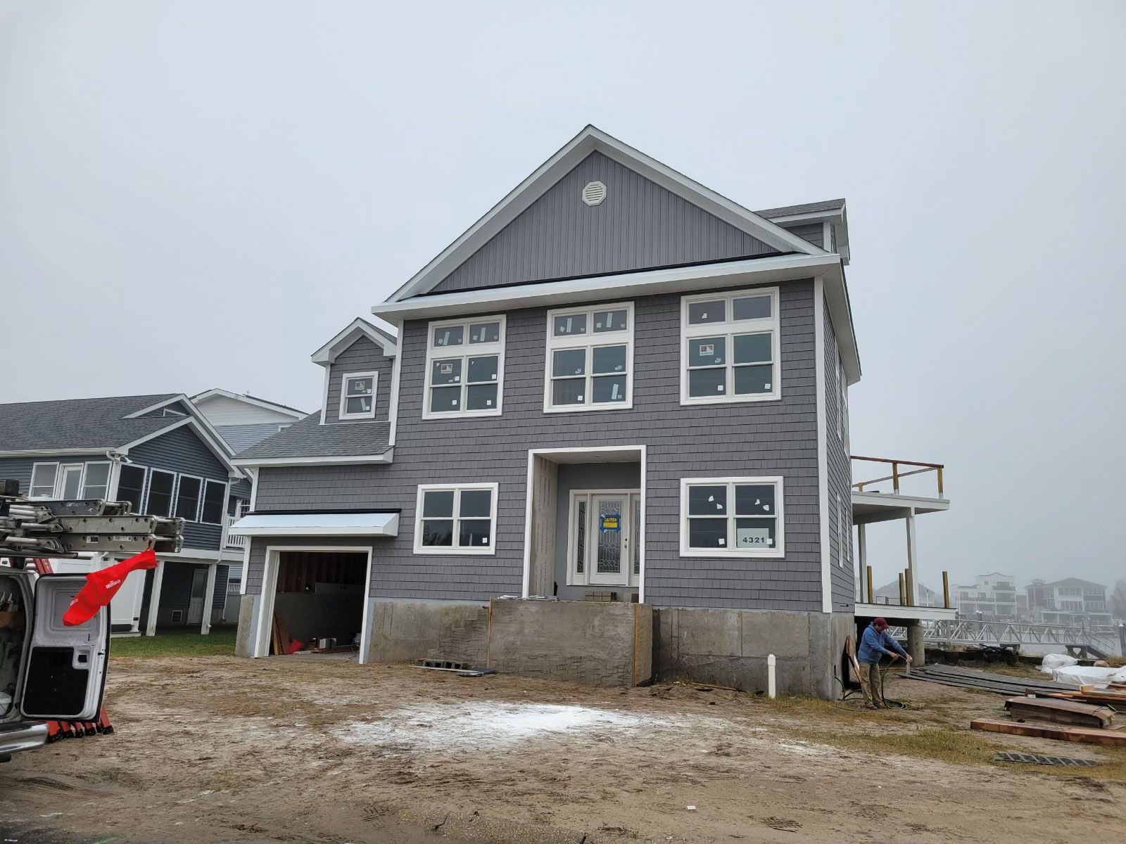 A large gray house with a lot of windows is being built