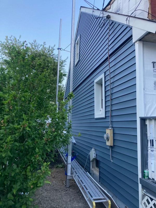 A house with a blue siding is being remodeled