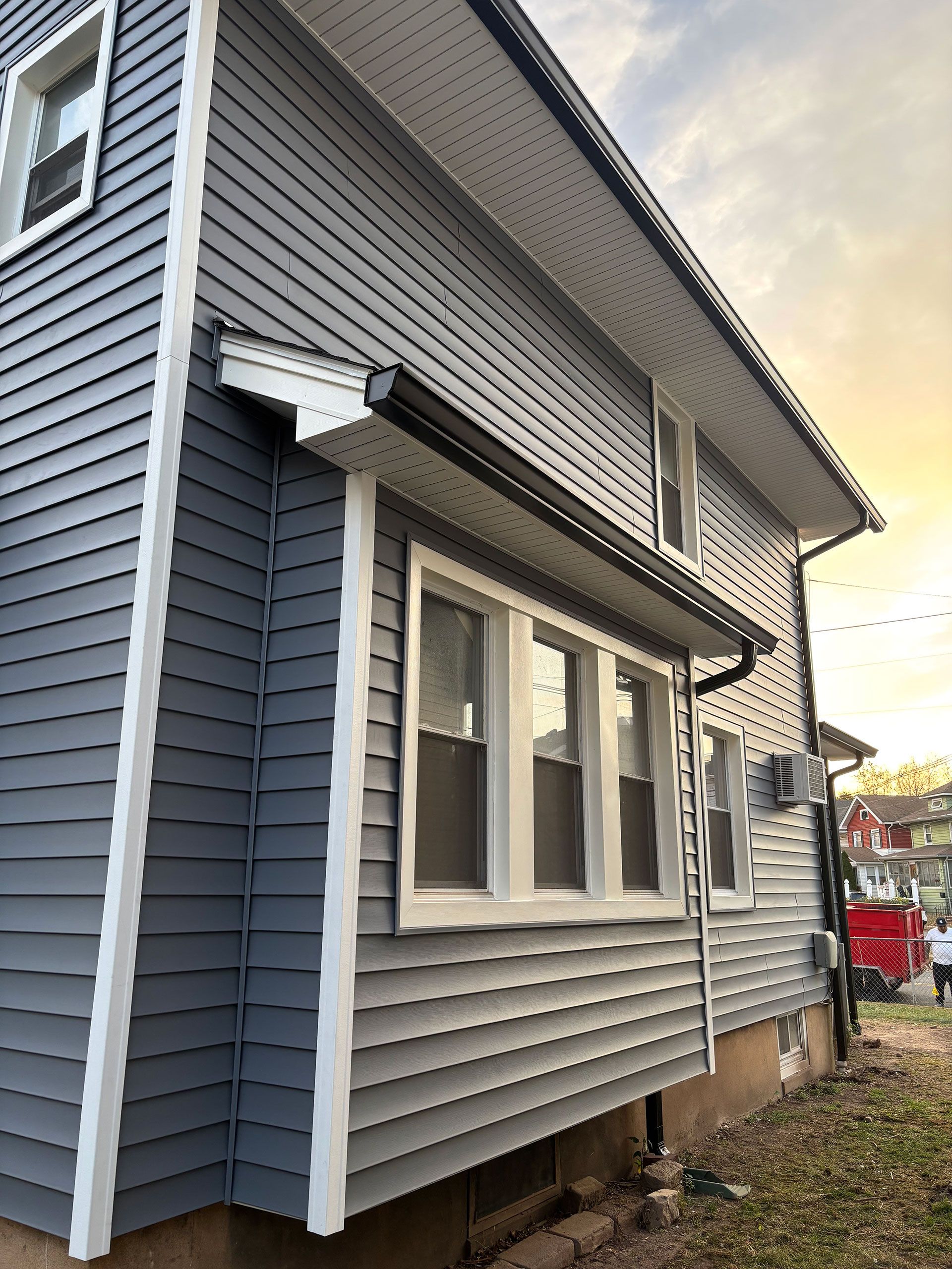 A house with a gray siding and white trim has a lot of windows