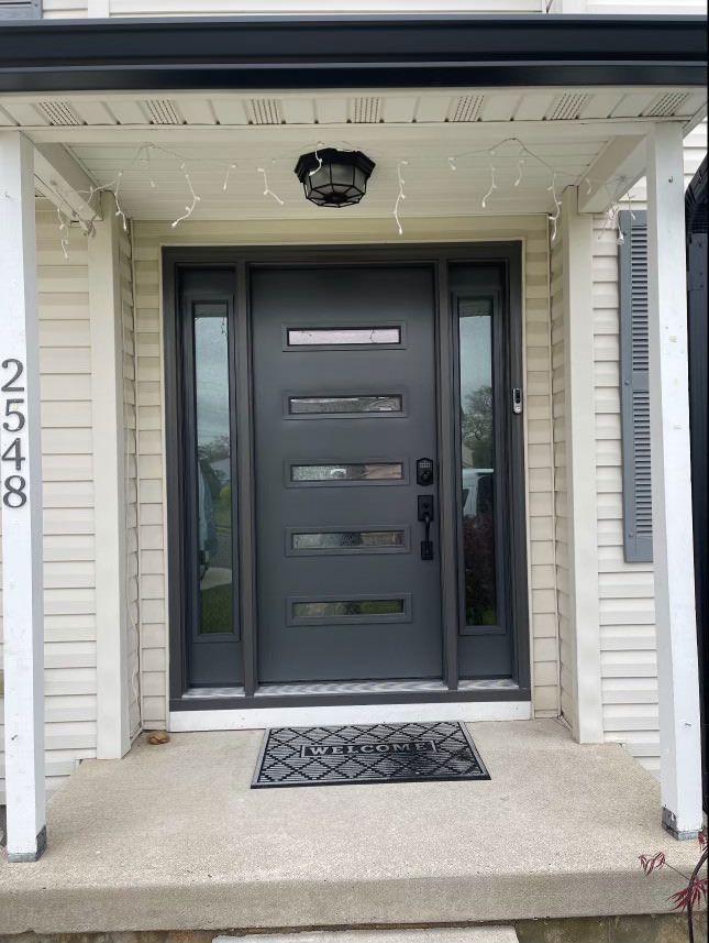 The front door of a white house with a black door