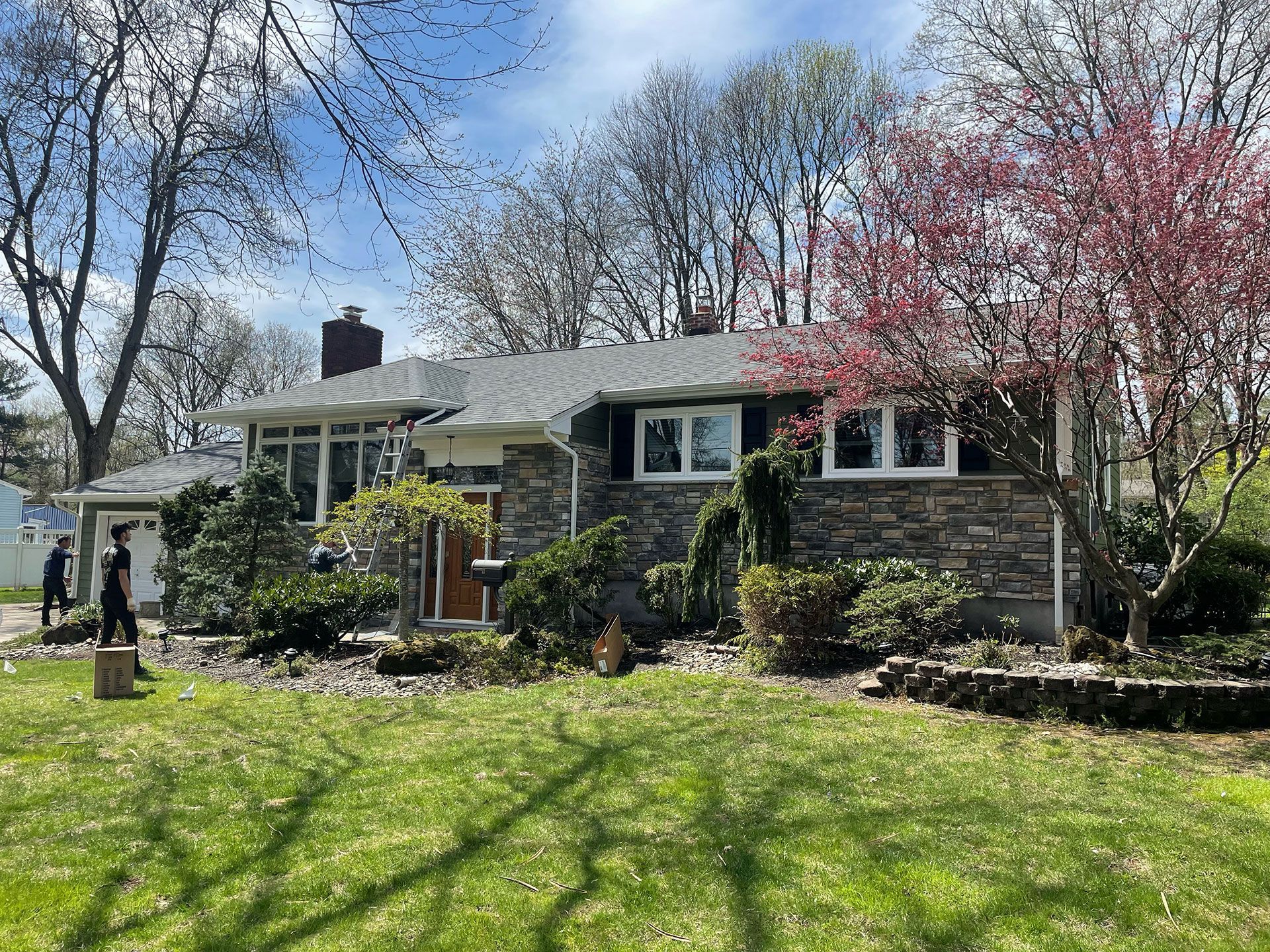 A house with a large lawn in front of it and trees in the background