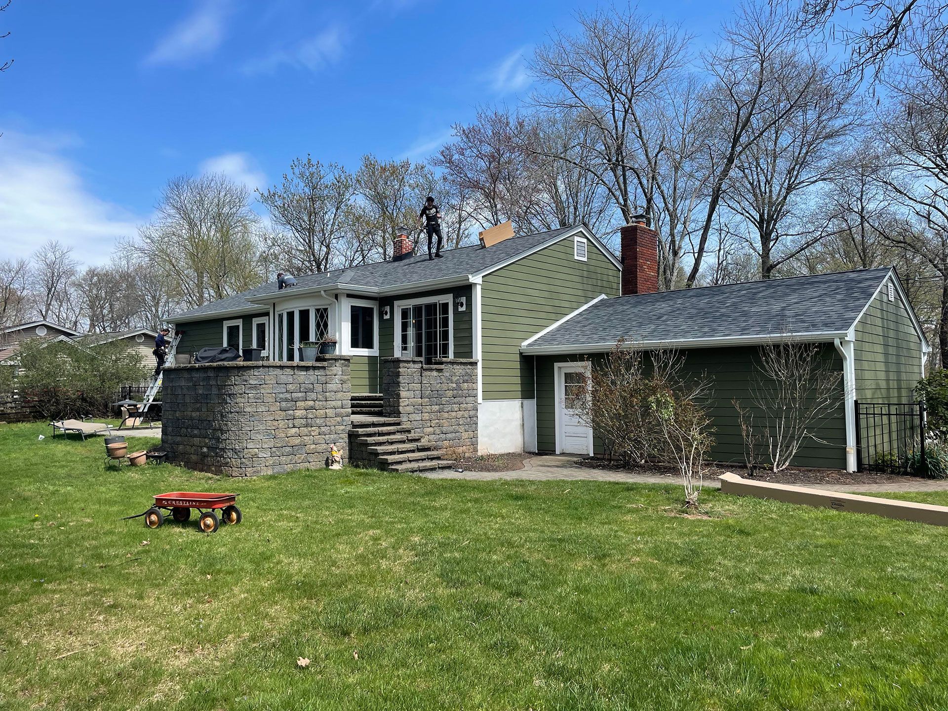 A green house with a gray roof is sitting on top of a lush green lawn