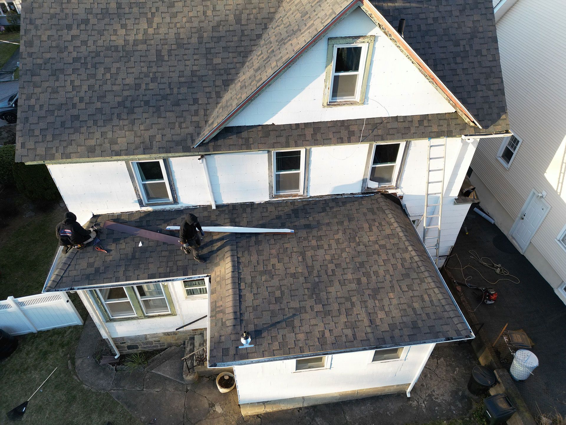 An aerial view of a house with a roof that is being repaired.