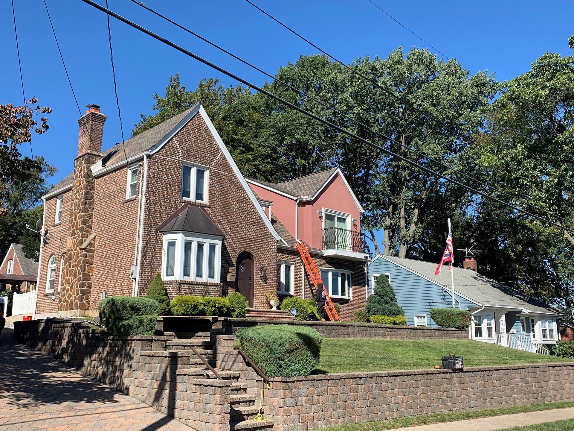 A brick house with a red house in the background
