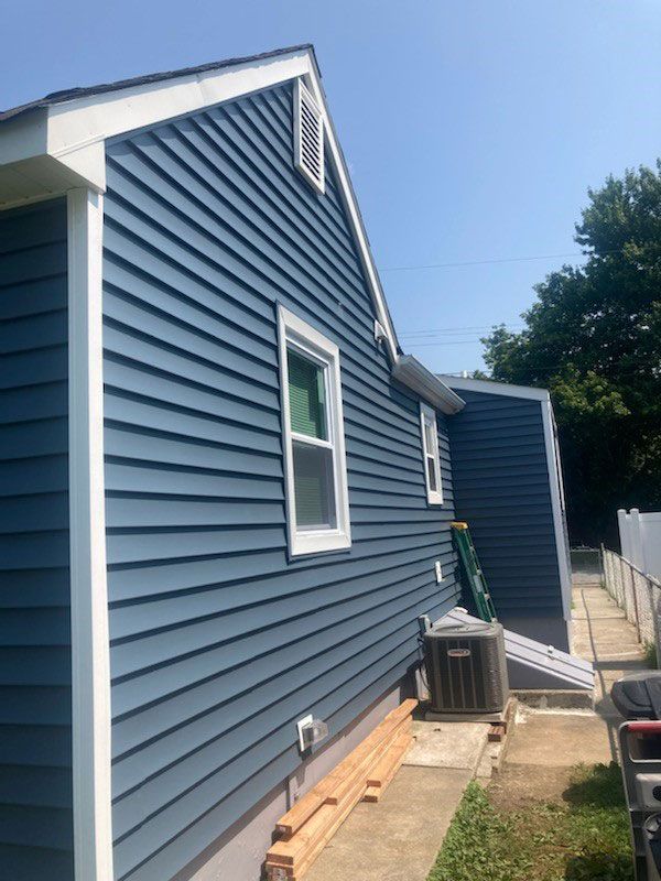 The side of a house with a blue siding and white trim