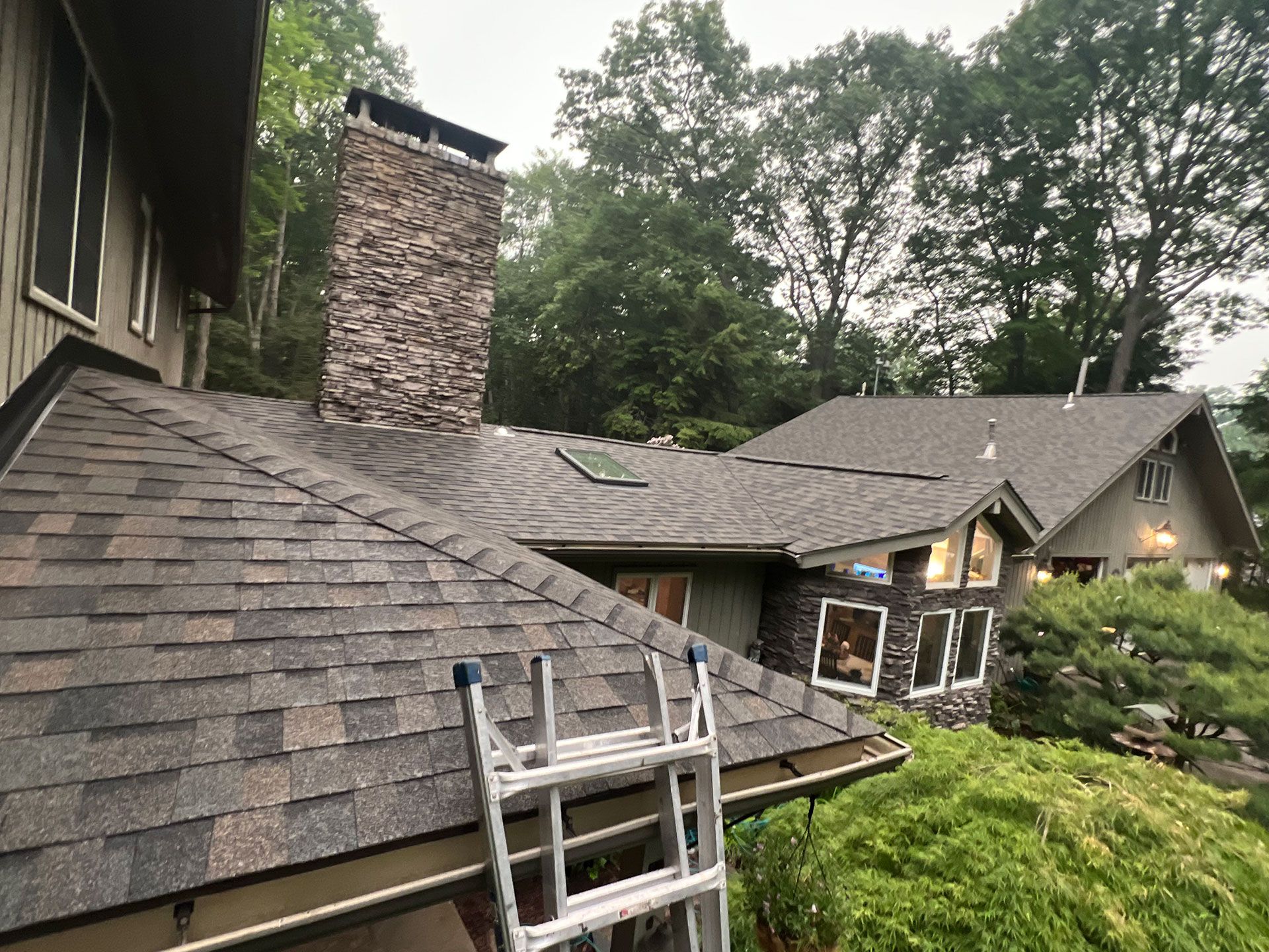 A ladder is sitting on the roof of a house