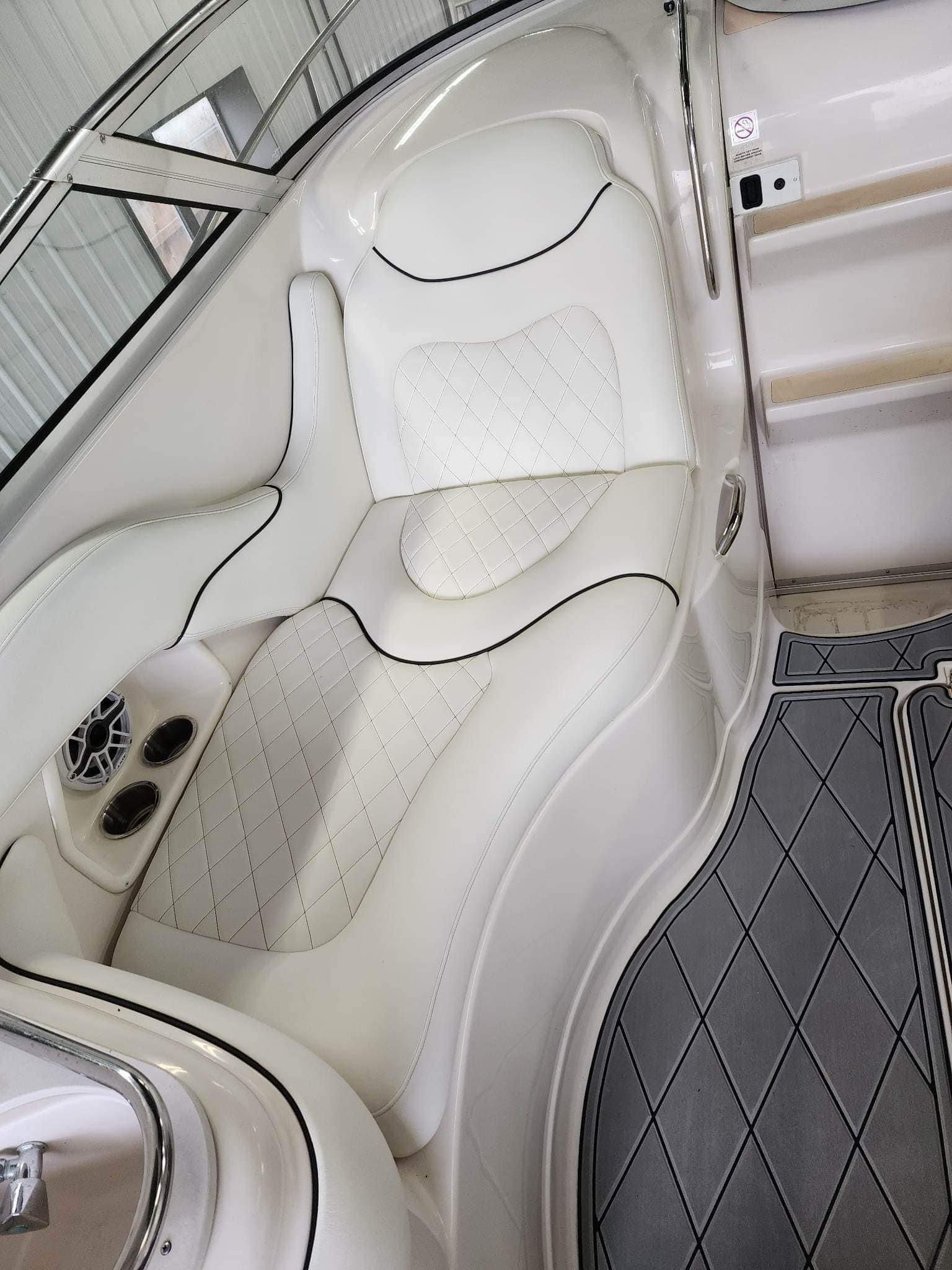 White boat interior with quilted seat, black trim, and gray flooring.