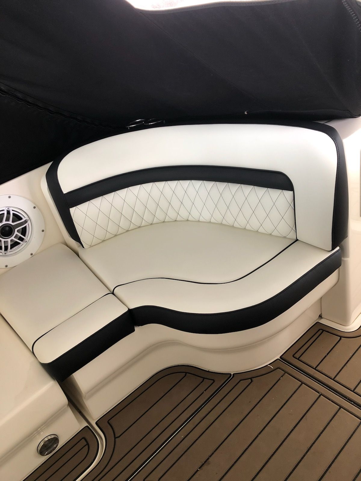 Boat seating with white and black upholstery; diamond-stitched backrest.