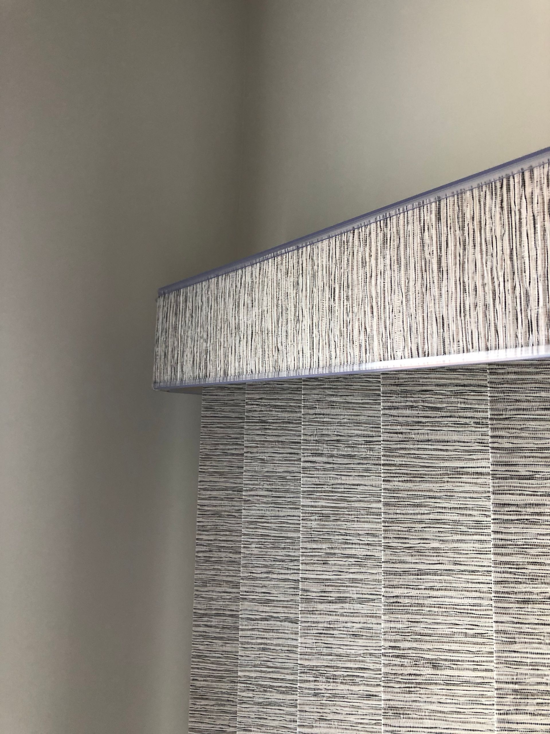 Gray and white striped tile backsplash with matching detail at the top corner, next to a plain gray wall.