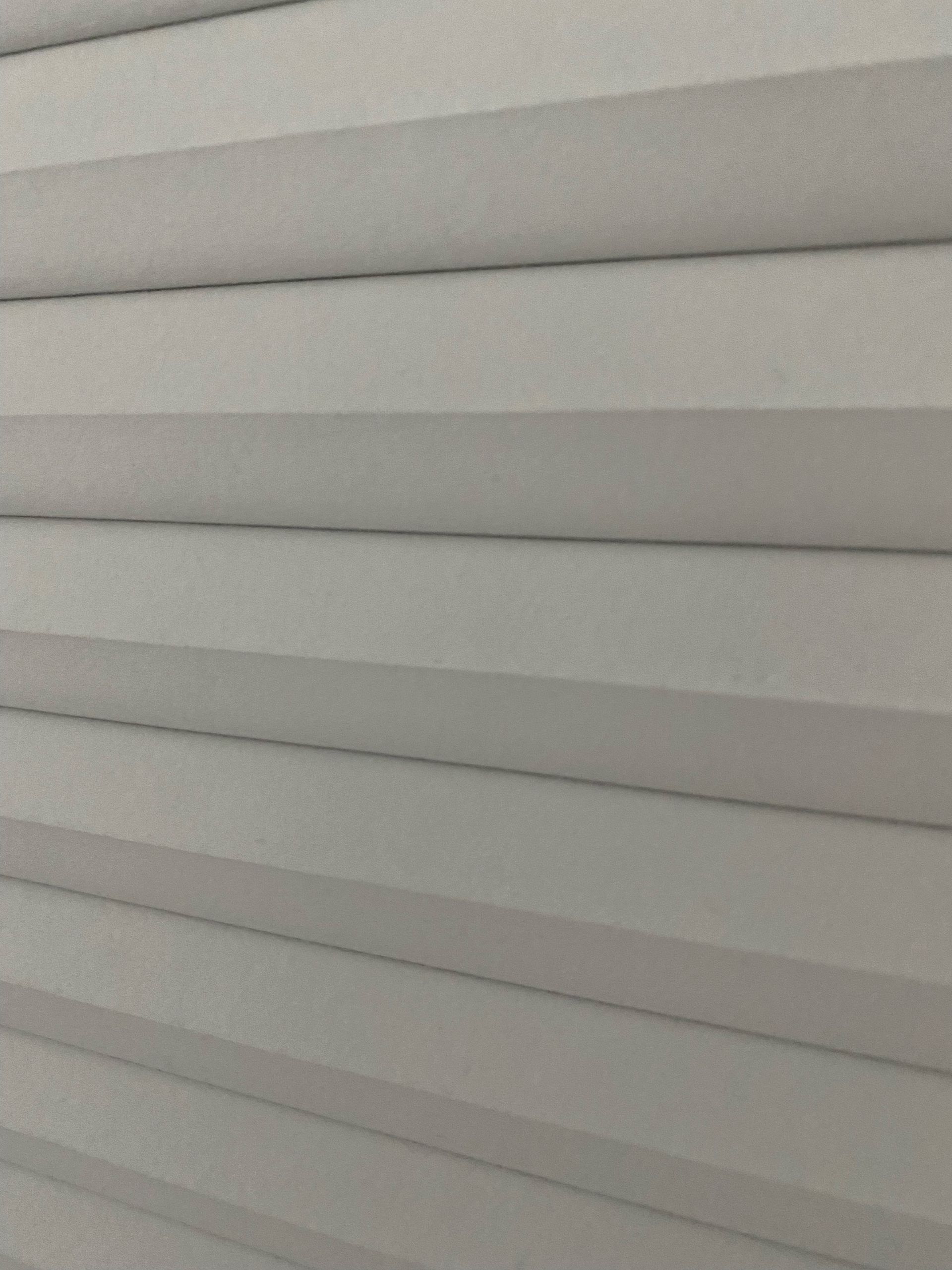 White, pleated cellular shade blinds, horizontal lines.
