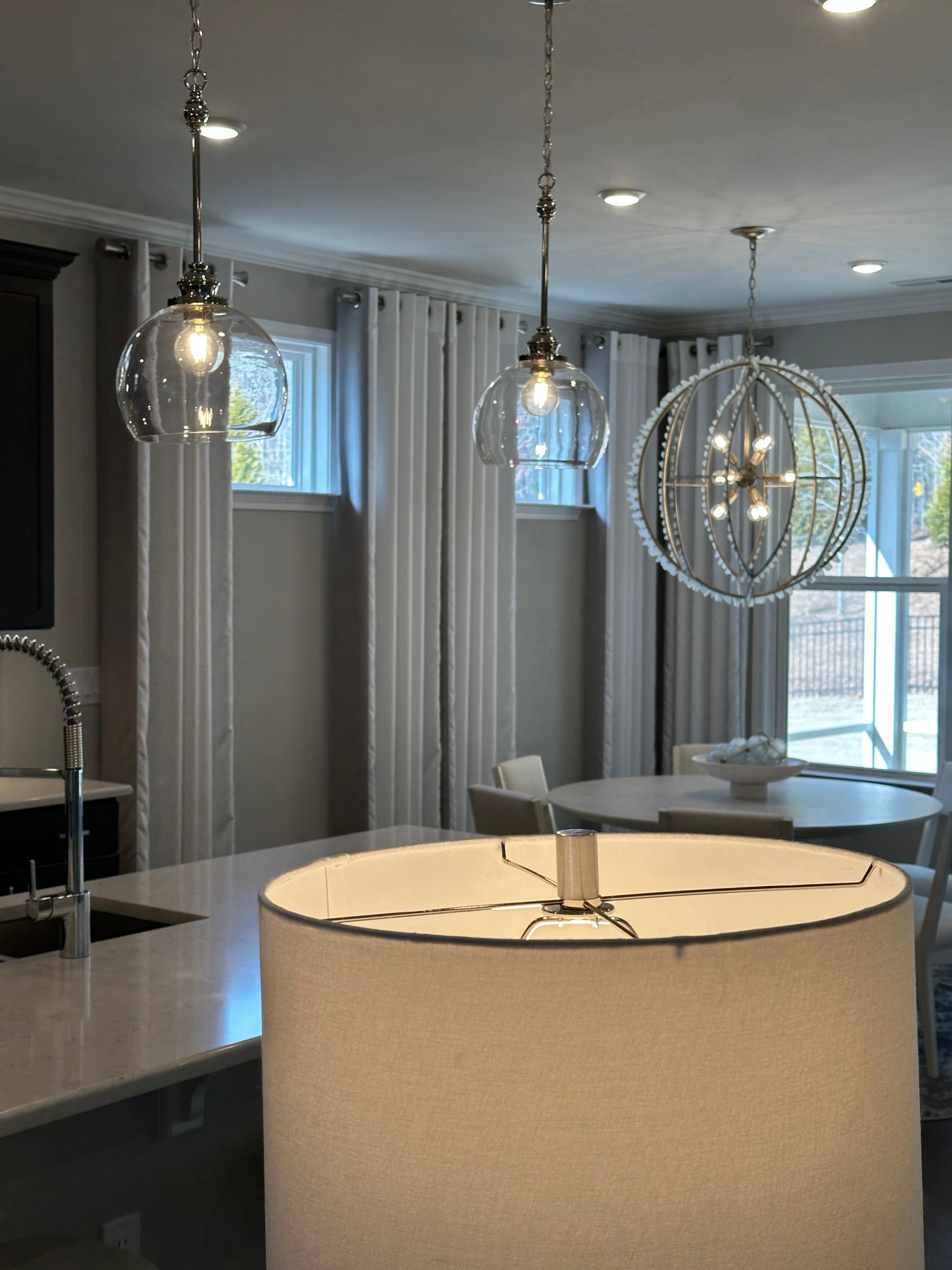 Kitchen with three pendant lights and a large lampshade in the foreground.