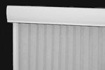 White vertical blinds, with a curved valance at the top, against a dark background.
