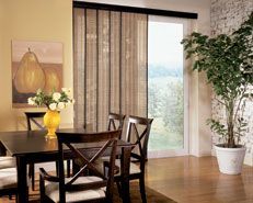 Dining room with dark wood table, chairs, and window with vertical blinds; painting of pears, and potted plant.