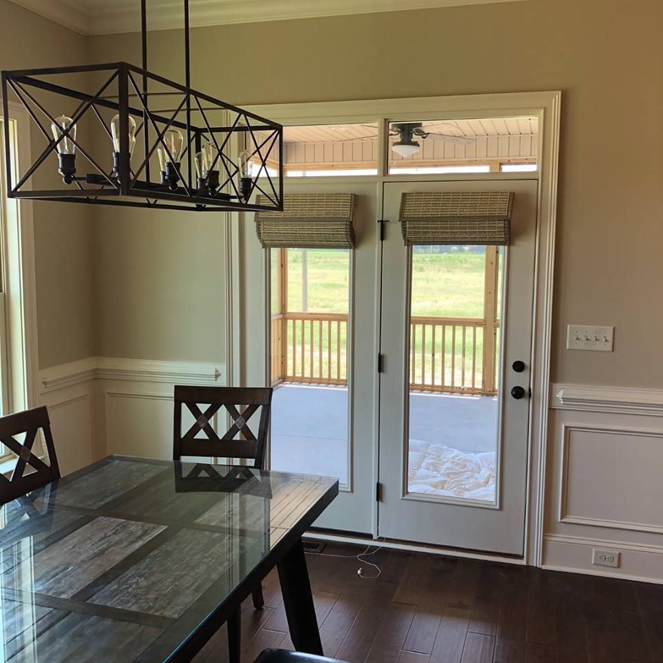 Dining room with dark table, two doors to patio, chandelier.