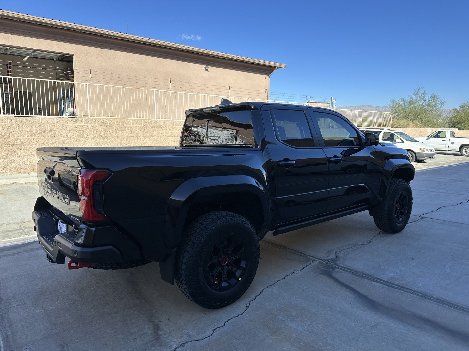 A black truck is parked in front of a building.