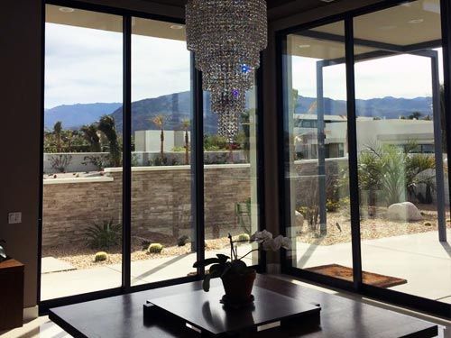 A living room with sliding glass doors and a chandelier hanging from the ceiling.