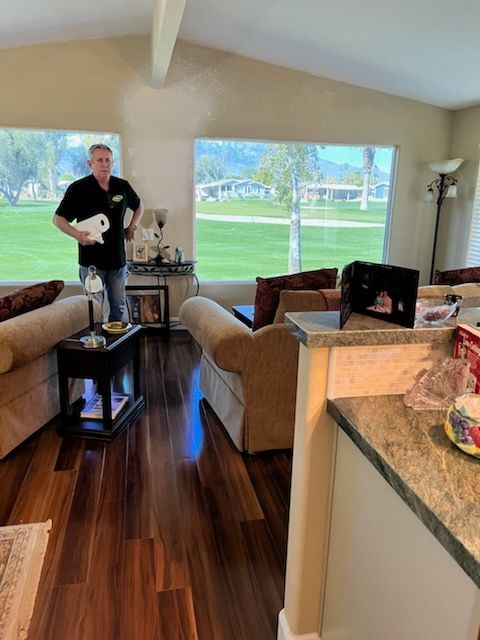 A man in a black shirt is standing in a living room