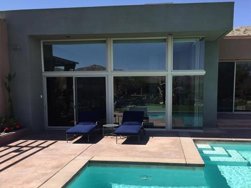 There is a swimming pool in the backyard of a house.