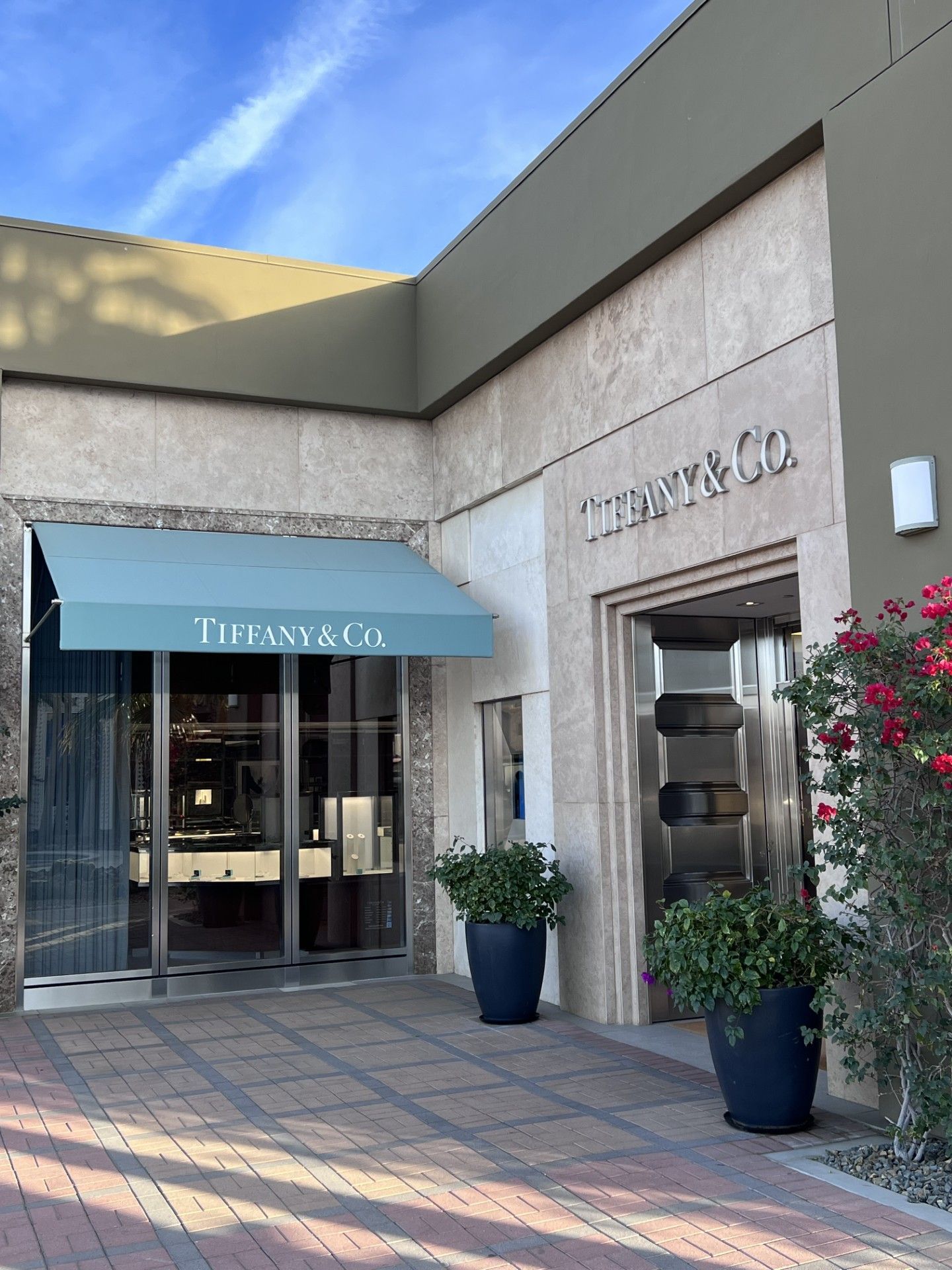 A tiffany & co. store with a blue awning over the entrance
