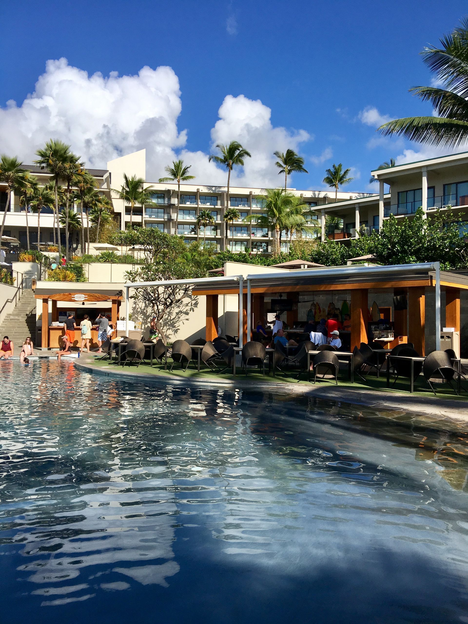 A large swimming pool with a restaurant in the background