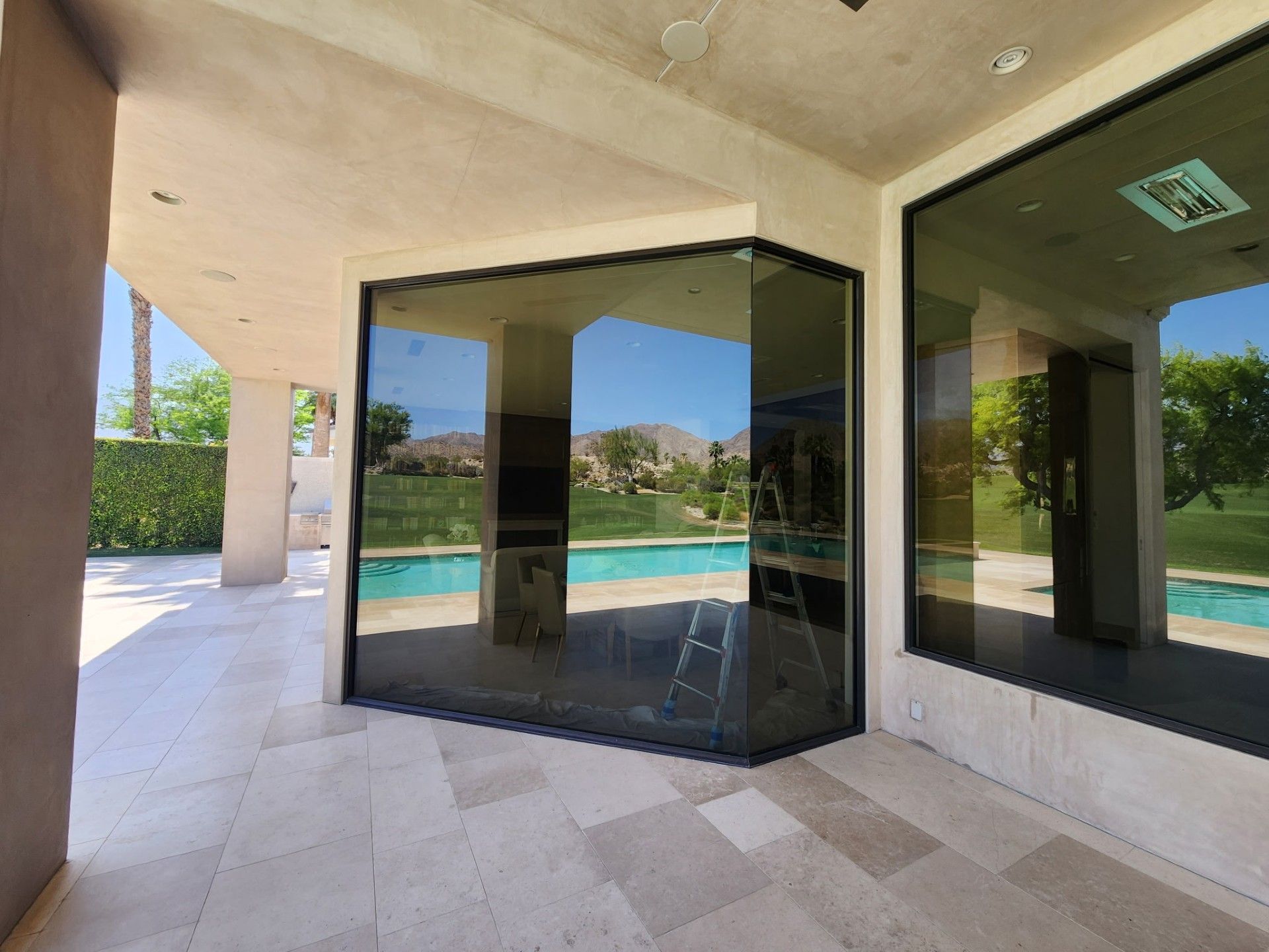 A large window with a reflection of a pool in it