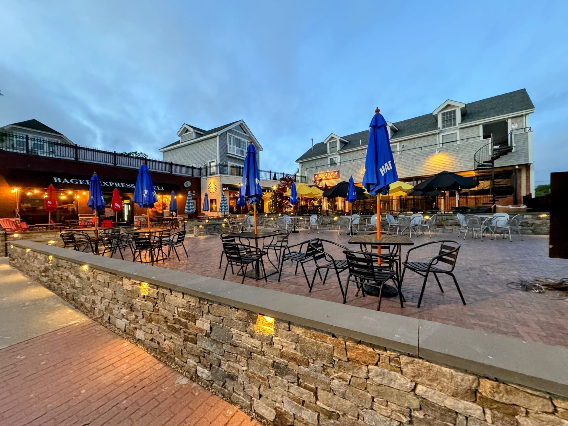 a restaurant with tables and chairs and umbrellas in front of it