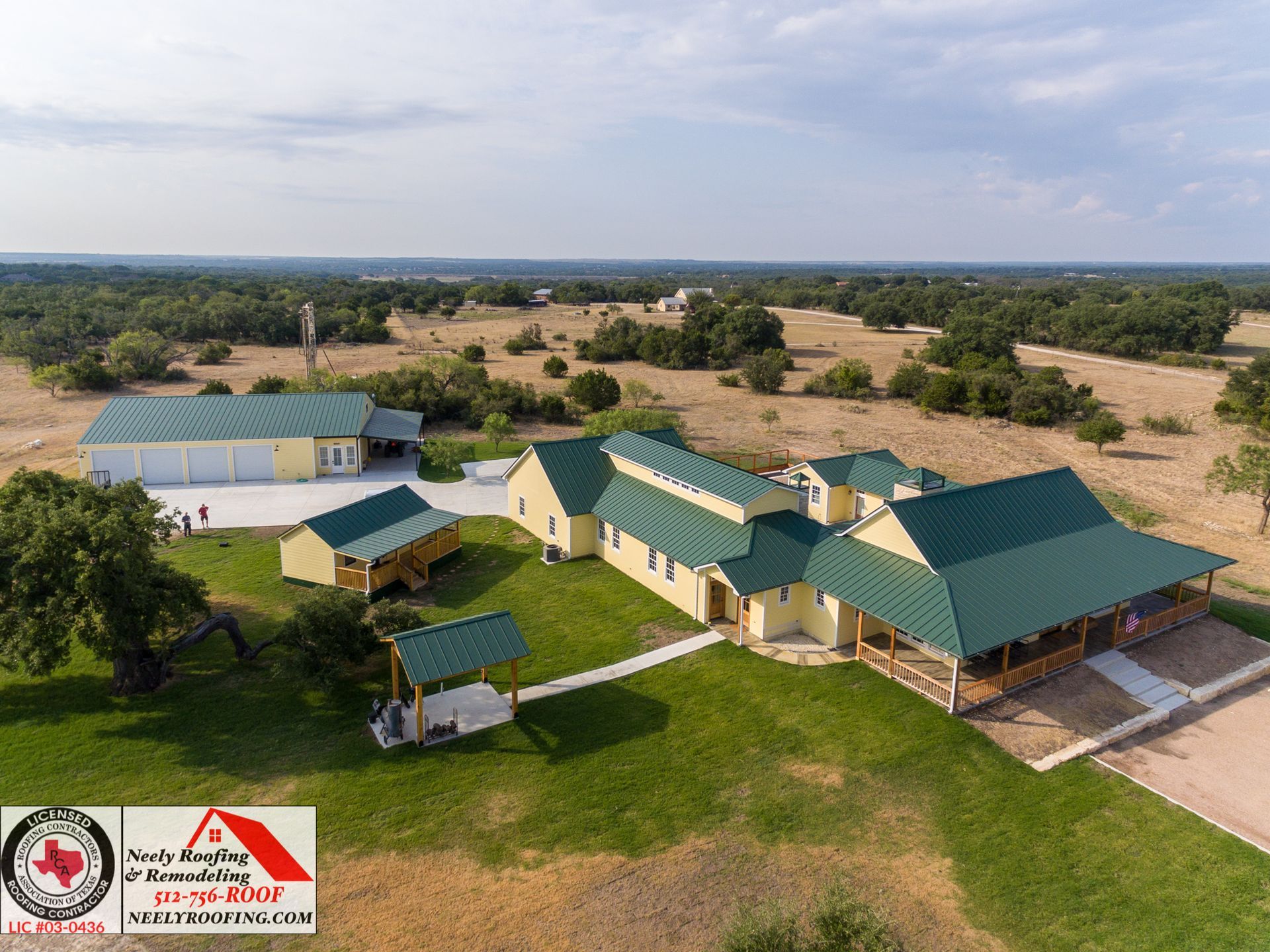 Aerial view of a rural complex with green-roofed buildings, paths, and open fields in a dry landscape