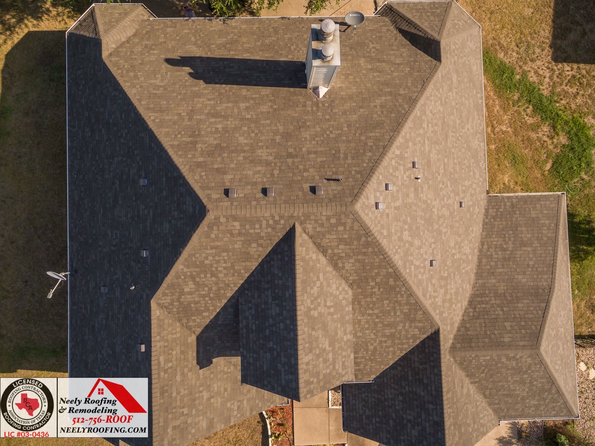 Aerial view of a tan shingled house roof with chimneys, vents, and attached garage roof.