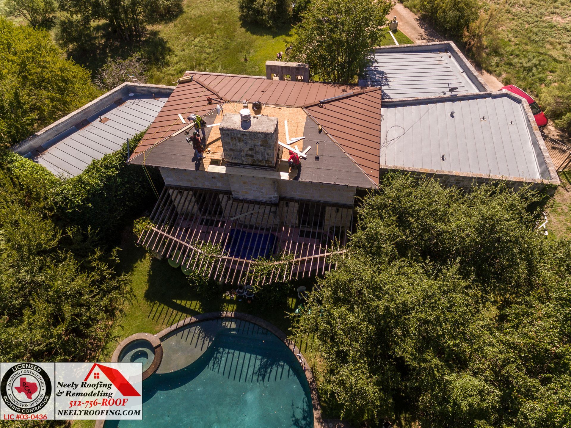 Aerial view of a house with a terracotta roof, surrounded by trees and a backyard pool.