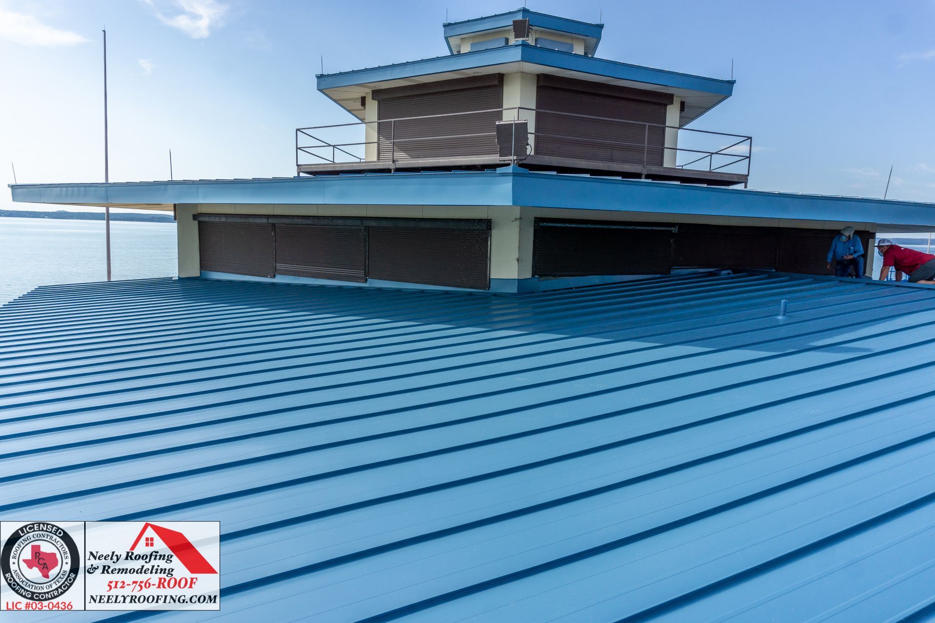 Blue metal rooftop with a small tower-like structure under a bright sky.