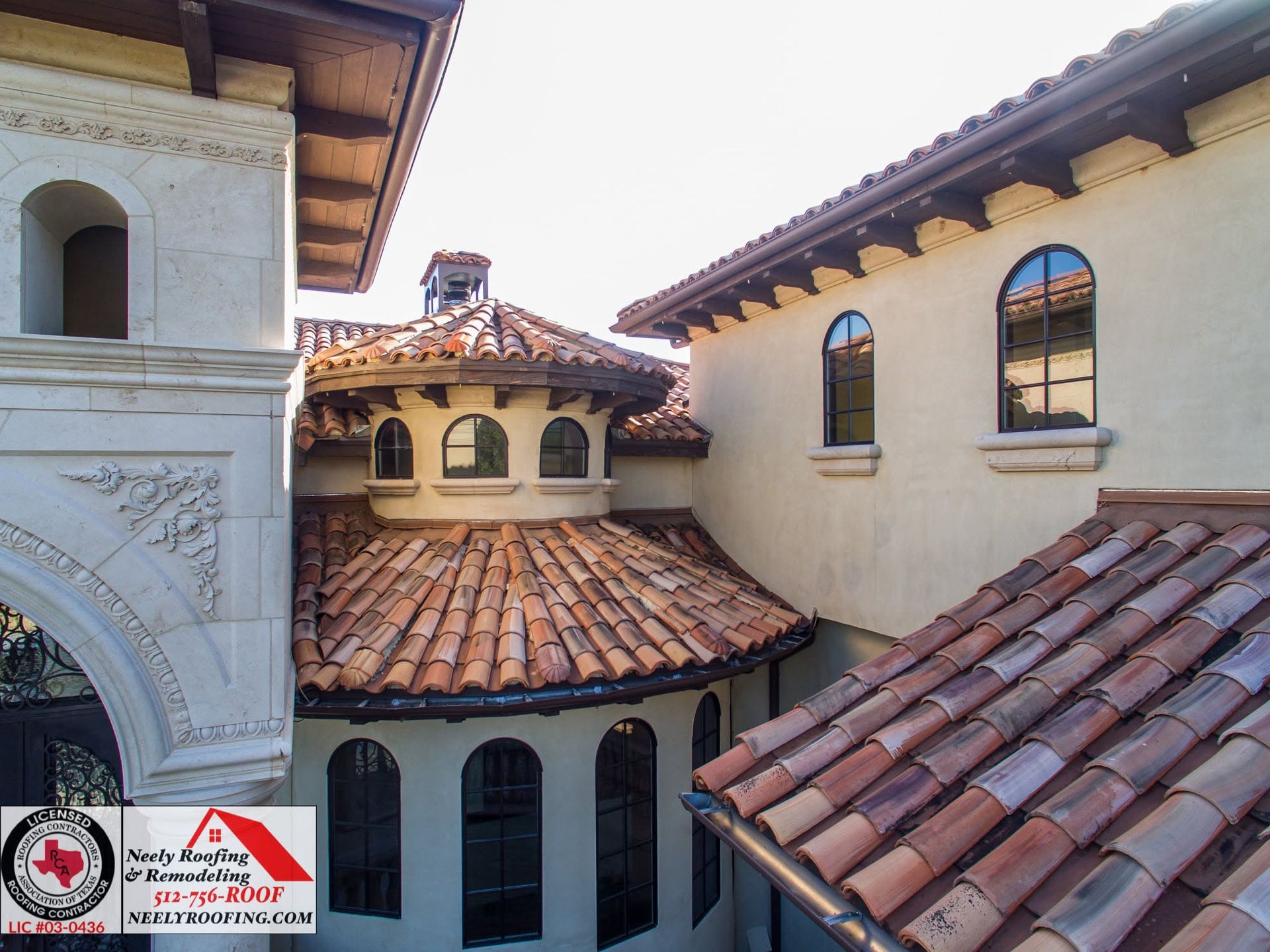 Spanish-style courtyard with red tile roofs and cream stucco walls under a bright sky