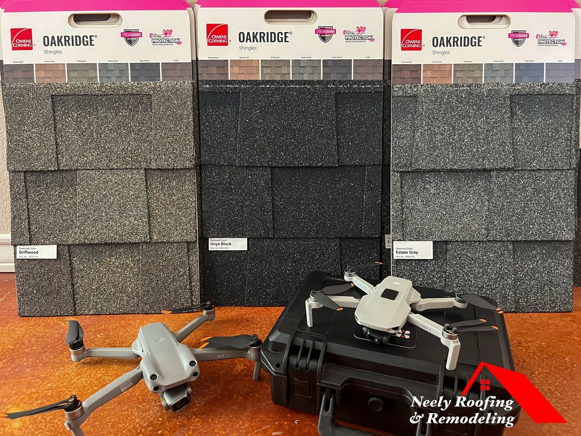 Two drone cameras on an orange surface in front of three carbon-fiber propeller guards display boards