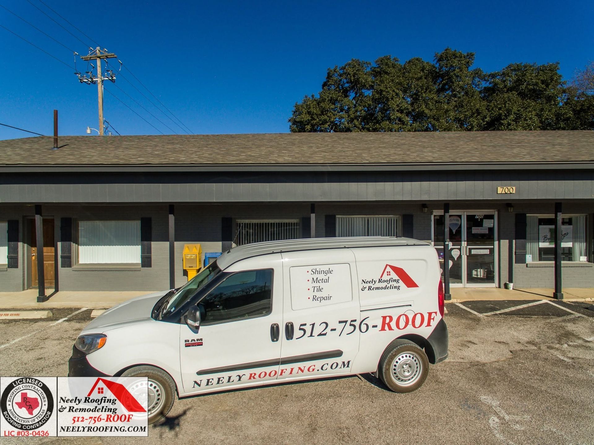 White service van parked outside a storefront, with red roofing-company branding and phone number on the side