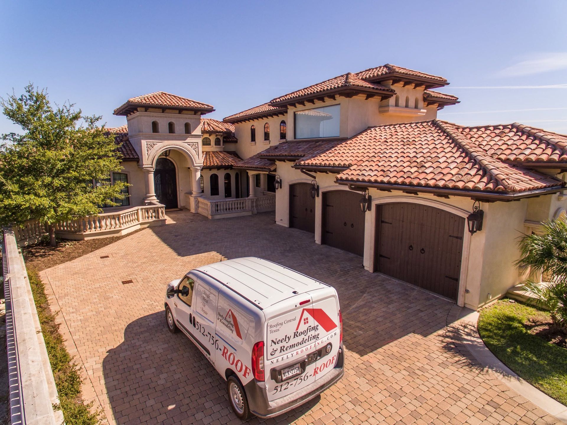 Mediterranean-style house with red tile roof and a white service van parked in the driveway