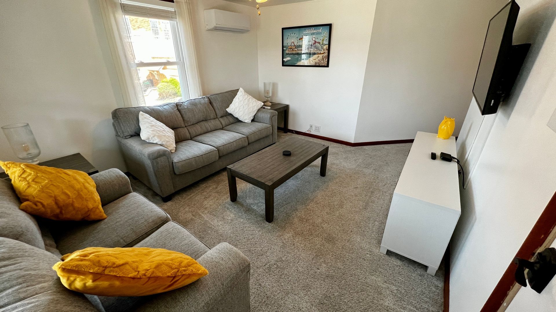 A living room with a couch , coffee table , and television.