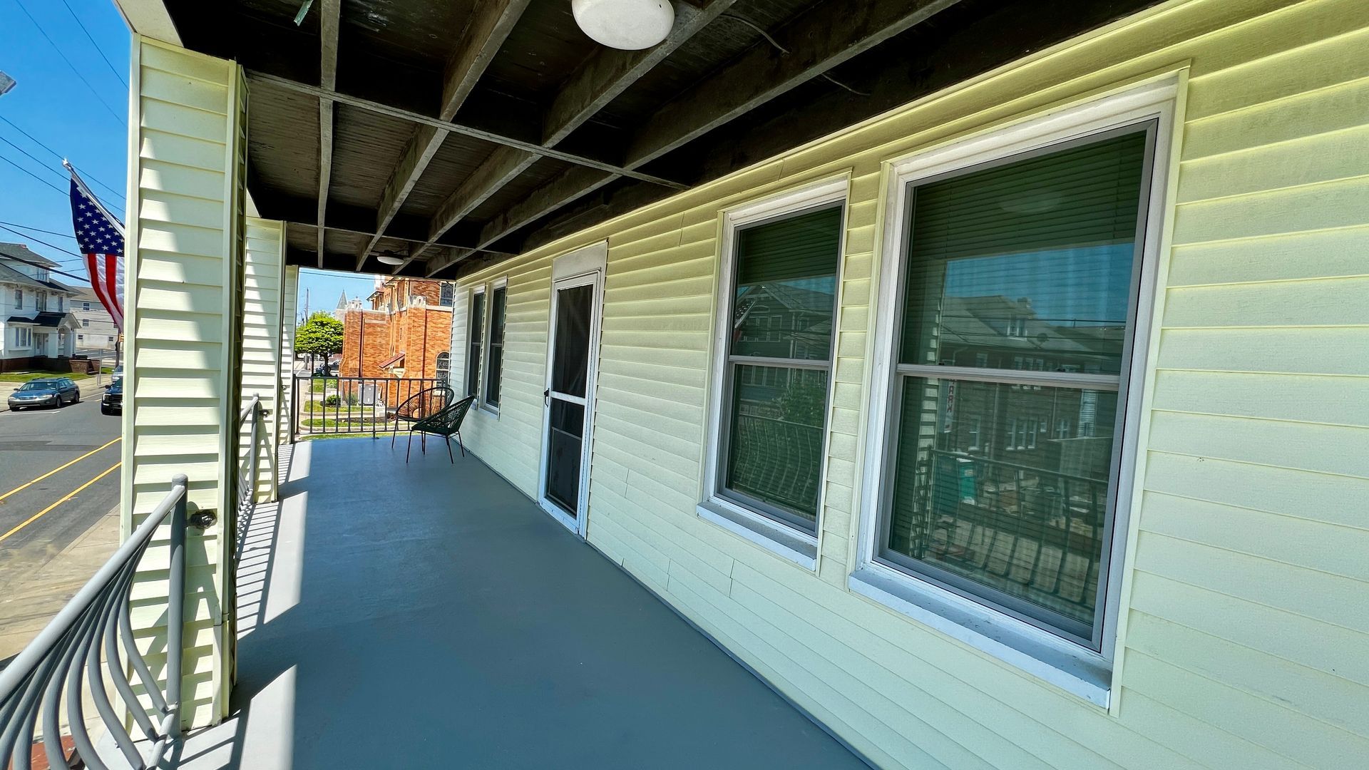A porch with a ceiling fan and a chair on it