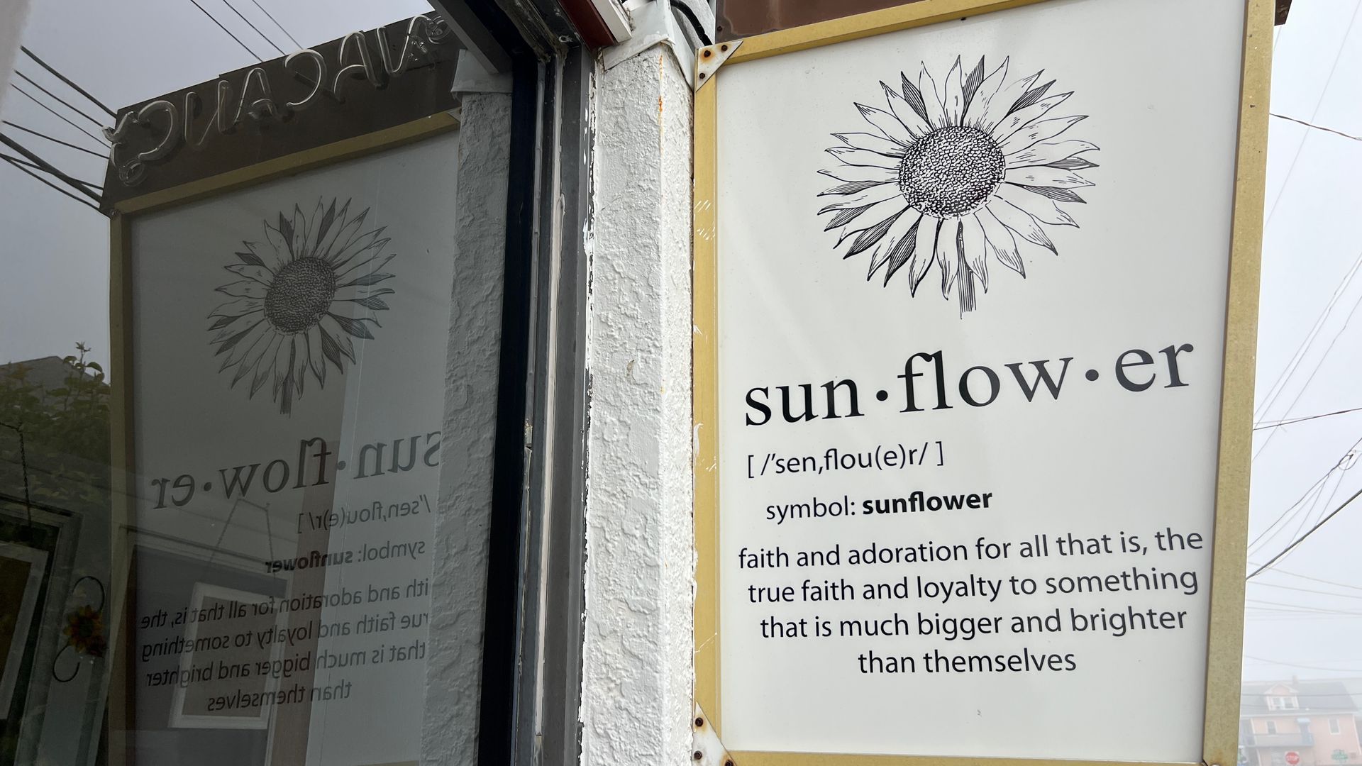 A sign on the side of a building that says sun-flow-er