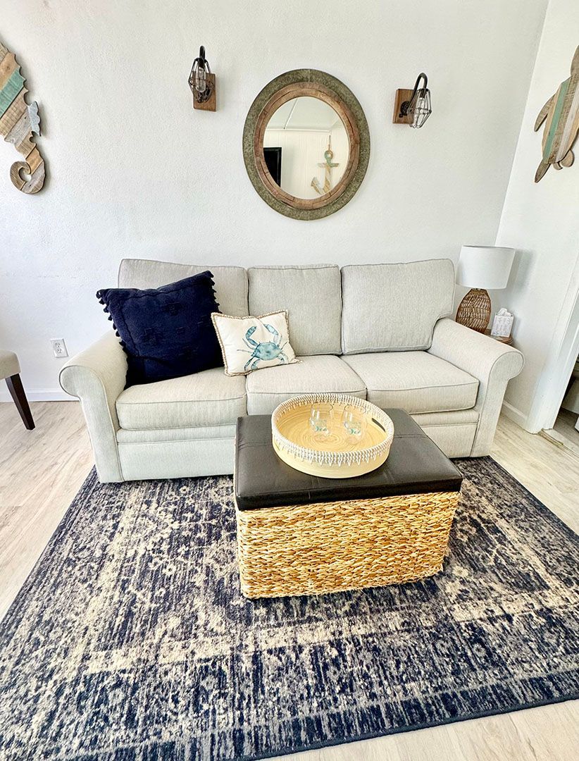 A living room with a couch, coffee table, and rug.